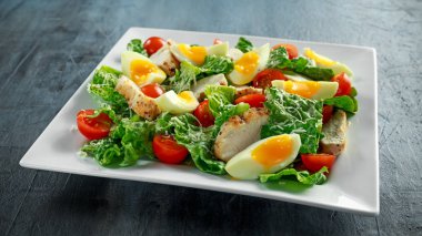 Tavuk, yumurta, domates, peynir ve Croutons beyaz plaka üzerinde taze sağlıklı Sezar salata