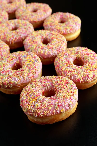 Iced doughnut rings with rainbow sparkl strands. — Stock Photo, Image