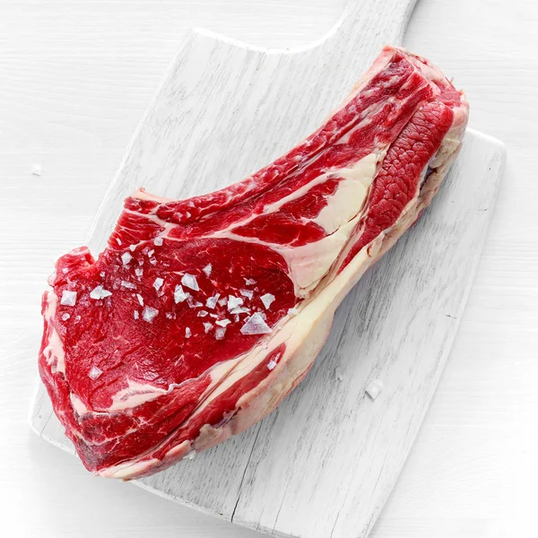 Fresh Raw Beef bone rib roughly choppid on white board with herbs — Stock Photo, Image