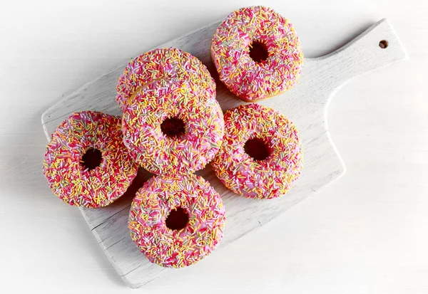 Iced doughnut rings with rainbow sparkl strands. — Stock Photo, Image