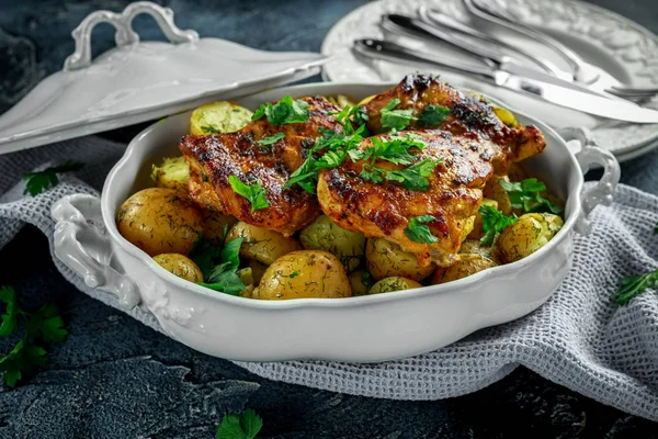 Pommes de terre bouillies neuves à l'aneth et au beurre servies avec cuisses de poulet désossées sans peau cuites au four dans une casserole vintage — Photo