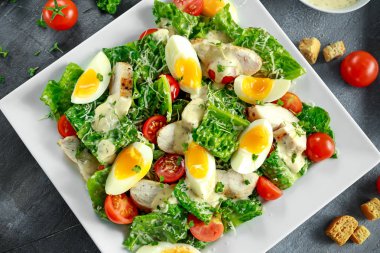 Tavuk, yumurta, domates, peynir ve Croutons beyaz plaka üzerinde taze sağlıklı Sezar salata