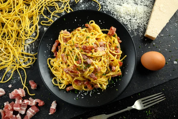 Класичний домашню пасту карбонара італійську з беконом, яєць, сиру пармезан на чорного плашкового кольору. — стокове фото