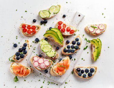 Ev yapımı yaz somon füme, yaban mersini, turp, salatalık, tere ve avokado salata krem peynirli tost. Taze sağlıklı kavramı gıda.
