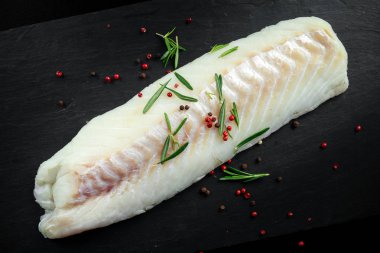 Taze çiğ morina fileto fileto rosemary ile biber taş tahta üzerinde kırık