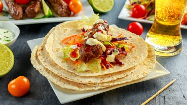 Ev yapımı köfte kebap pide, kireç, sebze, bira, beyaz plaka üzerinde tatlı biber ve yoğurt sos ile şiş üzerinde