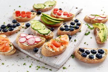 Ev yapımı yaz somon füme, yaban mersini, turp, salatalık, tere ve avokado salata krem peynirli tost. Taze sağlıklı kavramı gıda.