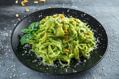 Siyah plaka üzerinde Tagliatelle makarna pesto sos, çam fıstığı ve parmesan ile.