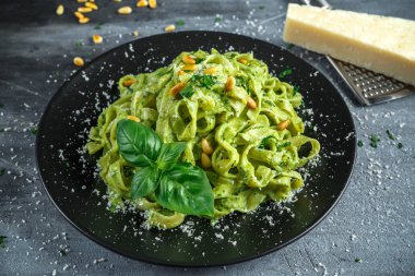 Siyah plaka üzerinde Tagliatelle makarna pesto sos, çam fıstığı ve parmesan ile.