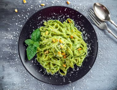 Siyah plaka üzerinde Tagliatelle makarna pesto sos, çam fıstığı ve parmesan ile.