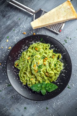 Siyah plaka üzerinde Tagliatelle makarna pesto sos, çam fıstığı ve parmesan ile.