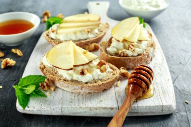 Meze bruschetta armut, bal, ceviz ve beyaz tahta üzerinde süzme peynir ile.