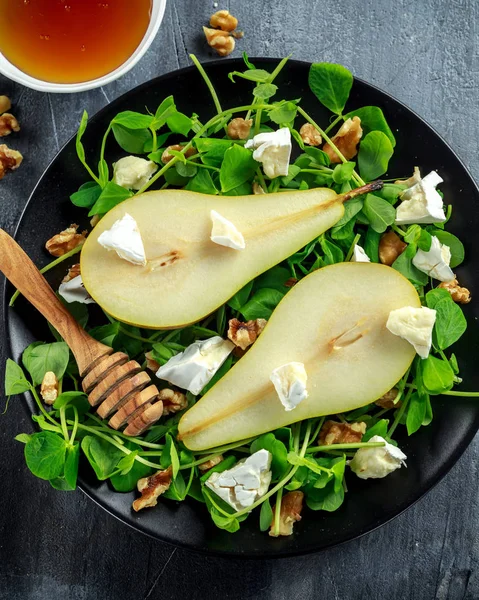 Fresh sweet Pears salad with walnuts, honey and white soft cheese on black plate — Stock Photo, Image