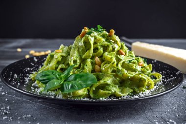 Siyah plaka üzerinde Tagliatelle makarna pesto sos, çam fıstığı ve parmesan ile.