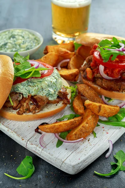 Deliciosos sanduíches de porco Bagel com molho vegetal e Tzatziki e batatas fritas na tábua branca . — Fotografia de Stock