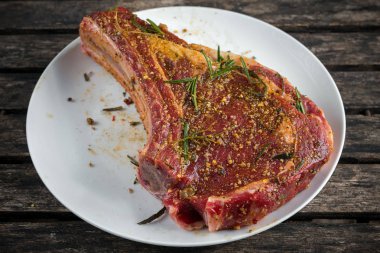 Taze çiğ dana kaburga sos beyaz plaka üzerinde otlar ile kemik.