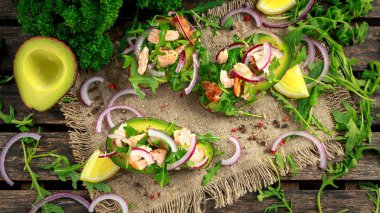 Avokado tekneler somon, kırmızı soğan ve roka ile doldurulmuş. kavram sağlıklı gıda