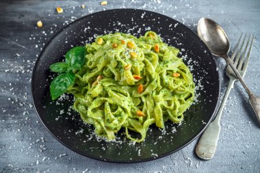 Siyah plaka üzerinde Tagliatelle makarna pesto sos, çam fıstığı ve parmesan ile.