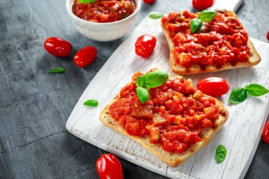 Taze ev yapımı gevrek İtalyan meze Bruschetta domates, patlıcan, kabak, sarı biber, sarımsak ve Beyaz ahşap tahta üzerinde fesleğen tepesinde. sağlıklı gıda