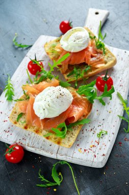 Izgara yumurtalı tost, füme somon, roka ve sebze. sağlıklı kahvaltı