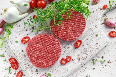 Taze çiğ et, yuvarlak ahşap beyaz tahta üzerinde ev yapımı hamburger yapmak için köftesi