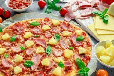 Taze pişmiş pizza hawaii ile jambon ve ananas, fesleğen, domates yedeklenmiş kağıt üzerinde