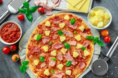 Taze pişmiş pizza hawaii ile jambon ve ananas, fesleğen, domates yedeklenmiş kağıt üzerinde