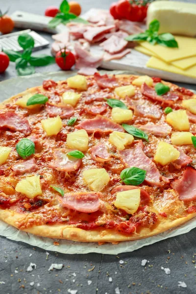 Taze pişmiş pizza hawaii ile jambon ve ananas, fesleğen, domates yedeklenmiş kağıt üzerinde