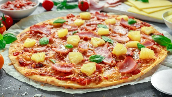 Taze pişmiş pizza hawaii ile jambon ve ananas, fesleğen, domates yedeklenmiş kağıt üzerinde