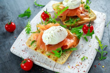Izgara yumurtalı tost, füme somon, roka ve sebze. sağlıklı kahvaltı
