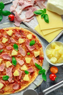 Taze pişmiş pizza hawaii ile jambon ve ananas, fesleğen, domates yedeklenmiş kağıt üzerinde