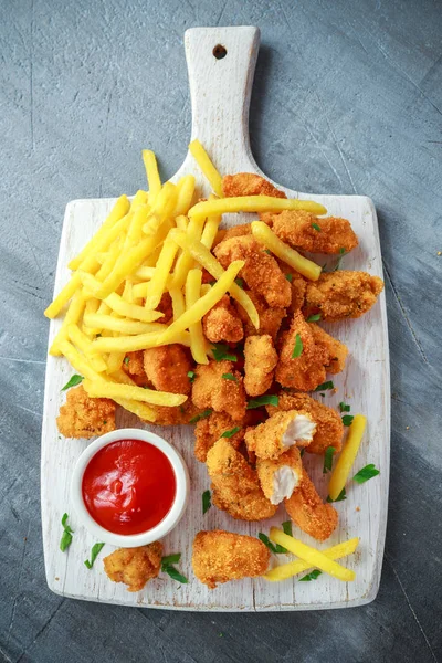 Stekt krispig kycklingnuggets med pommes frites och ketchup på vit bräda — Stockfoto