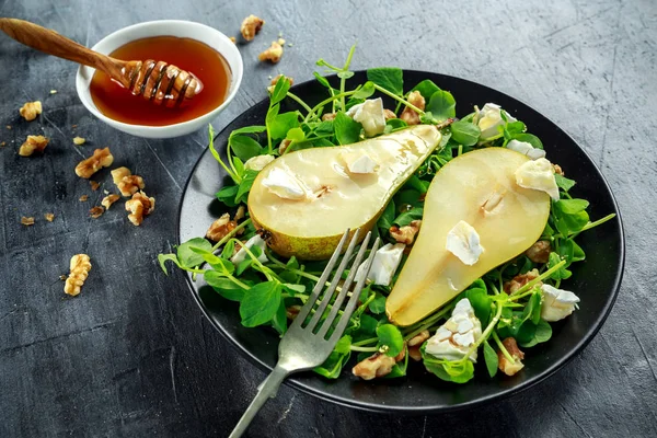 Fresh sweet Pears salad with walnuts, honey and white soft cheese on black plate — Stock Photo, Image