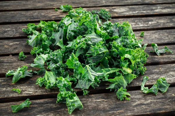 Frische grüne, gesunde Superfood-Grünkohlblätter auf rustikalem Holztisch — Stockfoto