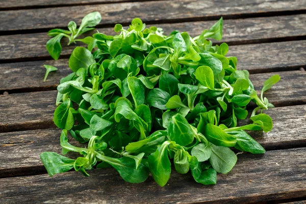 Frischer Feldsalat auf rustikalem Holztisch — Stockfoto