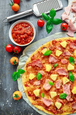 Taze pişmiş pizza hawaii ile jambon ve ananas, fesleğen, domates yedeklenmiş kağıt üzerinde