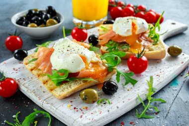 Somon füme, rucola, zeytin, sebze ve portakal suyu ile ızgara ekmek üzerine haşlanmış yumurta. Beyaz tahta üzerinde. sağlıklı kahvaltı