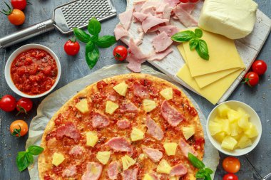 Taze pişmiş pizza hawaii ile jambon ve ananas, fesleğen, domates yedeklenmiş kağıt üzerinde
