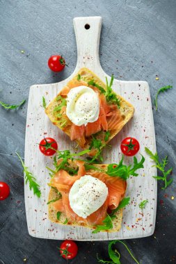 Izgara yumurtalı tost, füme somon, roka ve sebze. sağlıklı kahvaltı