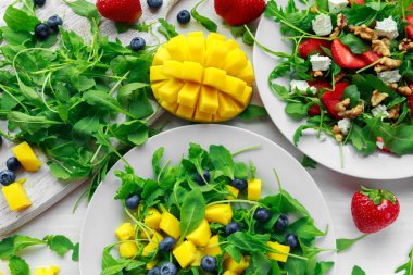 Mango, yaban mersini beyaz tabakta Roka Salatası