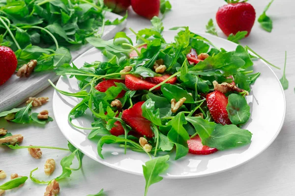 Färska jordgubbar sallad med ruccola på vit platta — Stockfoto