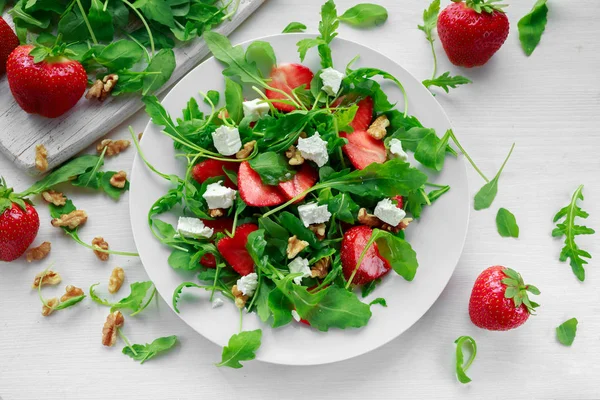 Insalata di fragole fresche con formaggio feta, rucola su piatto bianco — Foto Stock