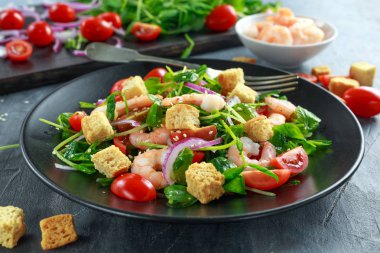 Siyah plaka üzerinde domates, kırmızı soğan ile taze sağlıklı karides salatası. kavram sağlıklı gıda