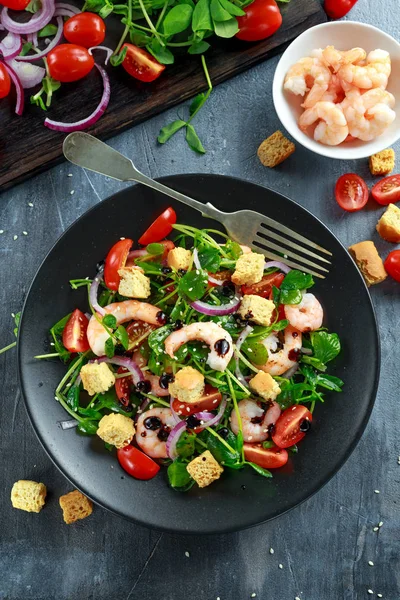 Siyah plaka üzerinde domates, kırmızı soğan ile taze sağlıklı karides salatası. kavram sağlıklı gıda