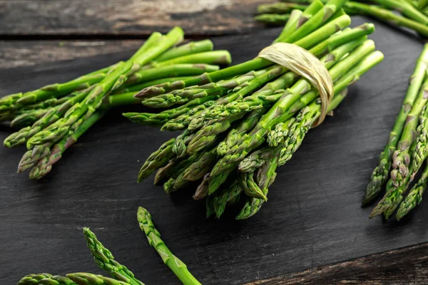 Ahşap doğrama tahtası üzerinde taze çiğ yeşil kuşkonmaz