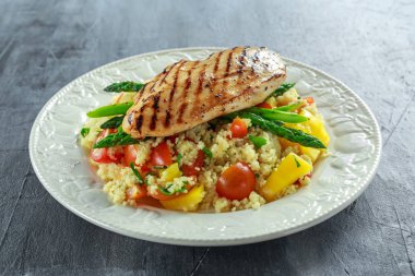 kuskus salata ızgara tavuk ve kuşkonmaz beyaz tabakta. sağlıklı gıda