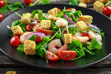 Siyah plaka üzerinde domates, kırmızı soğan ile taze sağlıklı karides salatası. kavram sağlıklı gıda