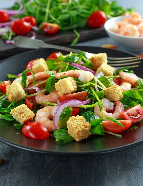 Siyah plaka üzerinde domates, kırmızı soğan ile taze sağlıklı karides salatası. kavram sağlıklı gıda