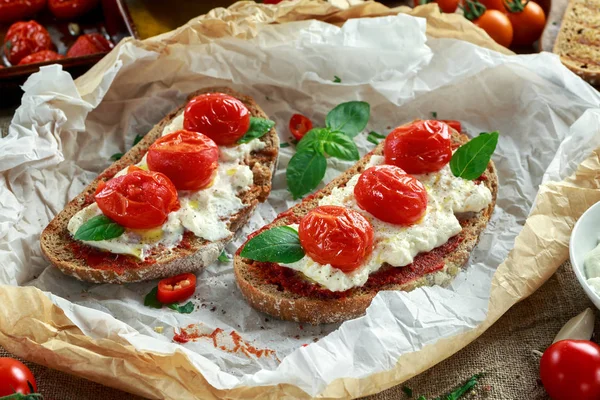 Tomate Ricotta Bruschetta con pasta de tomates secados al sol, aceite de oliva pan integral y albahaca — Foto de Stock