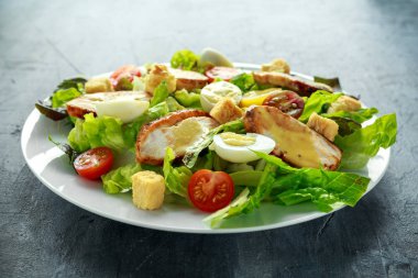 Taze sağlıklı Sezar salata tavuk, yumurta bıldırcın, domates, peynir ve Croutons beyaz bir tabak içinde